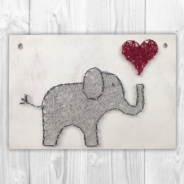 Fadenschild mit einem Elefanten und einem roten Herz auf weißem Hintergrund