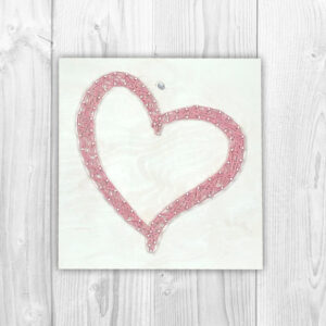 Fadenschild mit einem rosa Herz auf weißem Hintergrund